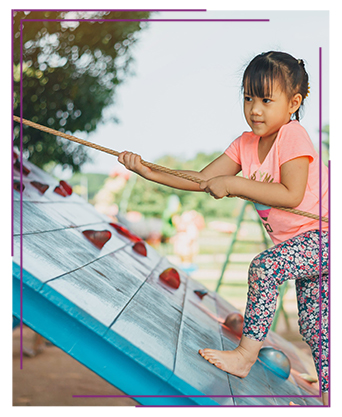 Happy little girl climbing on the playground